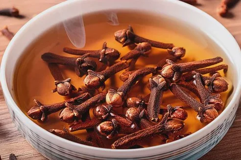 Infusión caliente con clavos de olor en un cuenco